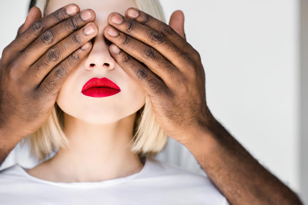 обрезанное изображение африканского американского бойфренда, закрывающего глаза на блондинку
 - Фото, изображение