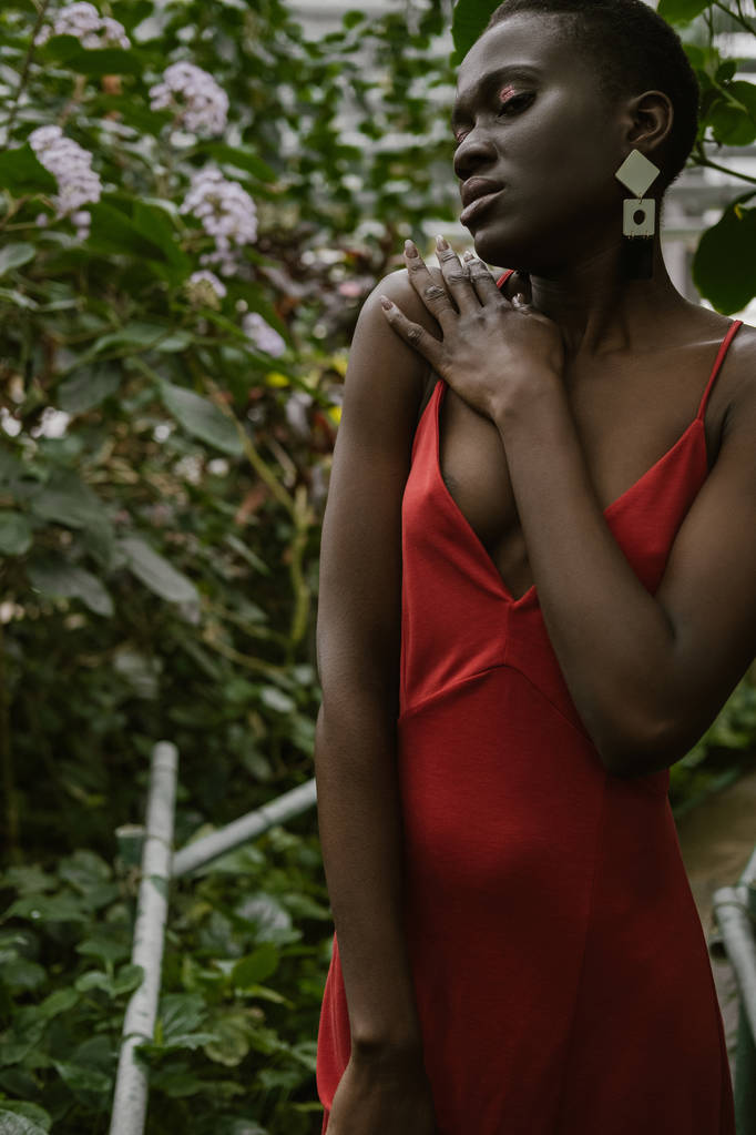 atractiva mujer afroamericana de moda posando en jardín tropical
 - Foto, imagen