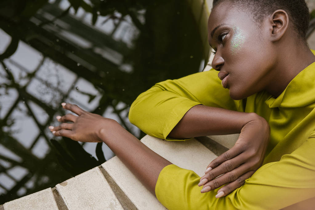 привлекательная нежная африканская американка с блестящим макияжем, позирующая у бассейна
 - Фото, изображение