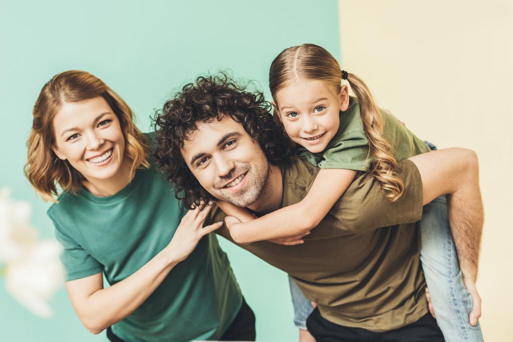 ευτυχισμένη οικογένεια με ένα παιδί να διασκεδάσουμε μαζί και να χαμογελά στη φωτογραφική μηχανή - Φωτογραφία, εικόνα