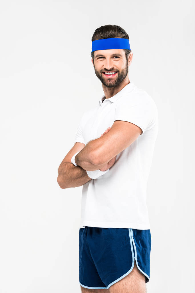 vrolijke sportman in retro sportkleding met gekruiste armen, geïsoleerd op wit - Foto, afbeelding
