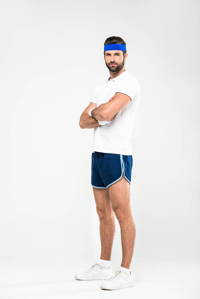przystojny sportowiec w retro Odzież sportowa z skrzyżowanymi rękami, na białym tle - Zdjęcie, obraz