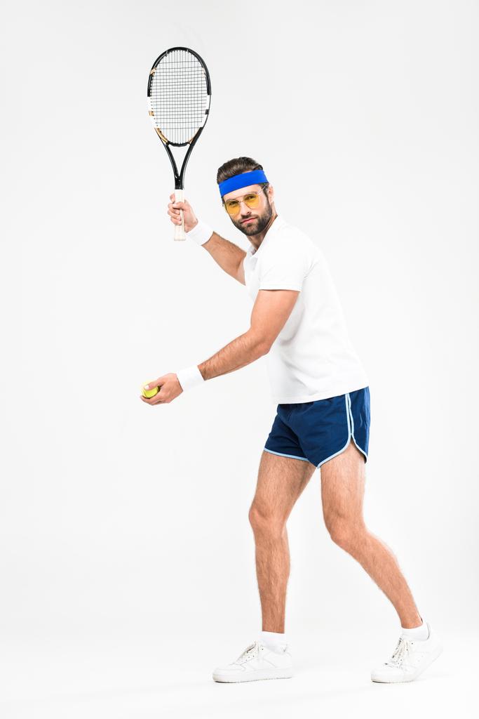 sportovec v retro sluneční brýle hrát tenis raketa a míček, izolované na bílém  - Fotografie, Obrázek