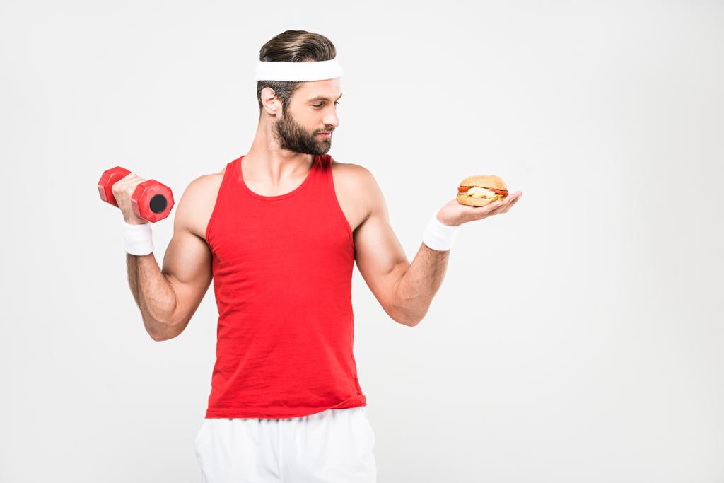 sportsman choosing junk food or sporty healthy lifestyle, isolated on white - Photo, Image