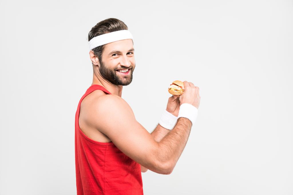 sportovec, jíst chutné hamburger, izolované na bílém - Fotografie, Obrázek