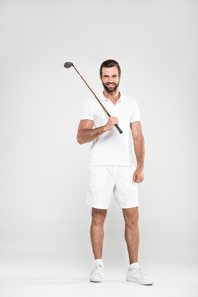 веселый мужчина гольфист в белой спортивной одежде с клюшкой для гольфа, изолированный на сером
 - Фото, изображение