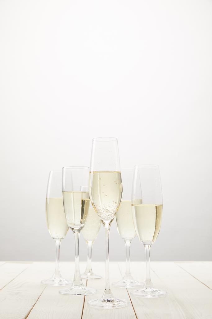 closeup view of champagne glasses on white wooden table  - Photo, Image
