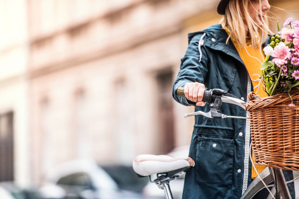 Giovane donna con bicicletta nella soleggiata città primaverile
. - Foto, immagini