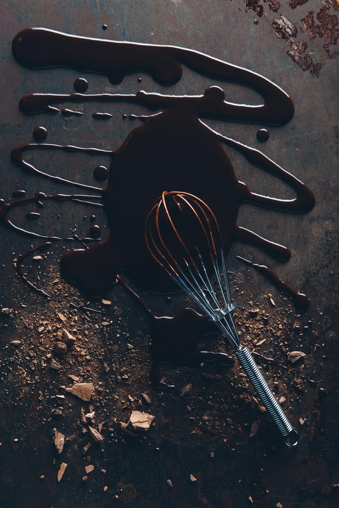bovenaanzicht van de garde en heerlijke gesmolten chocolade op donkere ondergrond - Foto, afbeelding