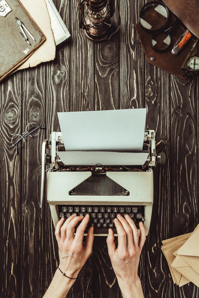 vista parziale della dattilografia dello scrittore sulla macchina da scrivere con buste bianche e lenti d'ingrandimento su piano in legno
 - Foto, immagini