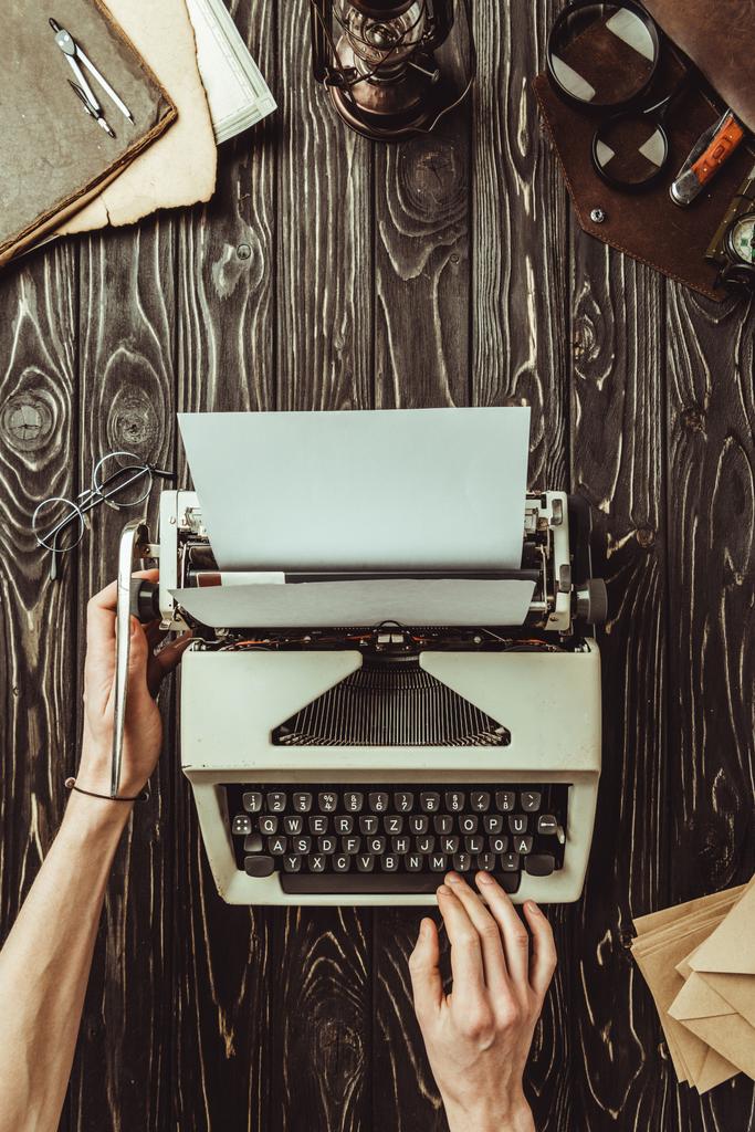 частковий вигляд рук письменника, друкарська машинка та конверти на дерев'яній стільниці
 - Фото, зображення