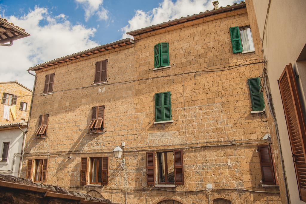 Fenster mit braunen und grünen Fensterläden in orvieto, rom vorort, italien  - Foto, Bild
