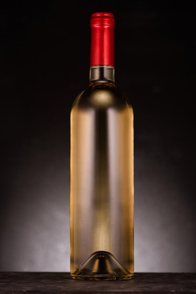ενιαίο μπουκάλι κρασί πολυτελή λευκό σε μαύρο - Φωτογραφία, εικόνα