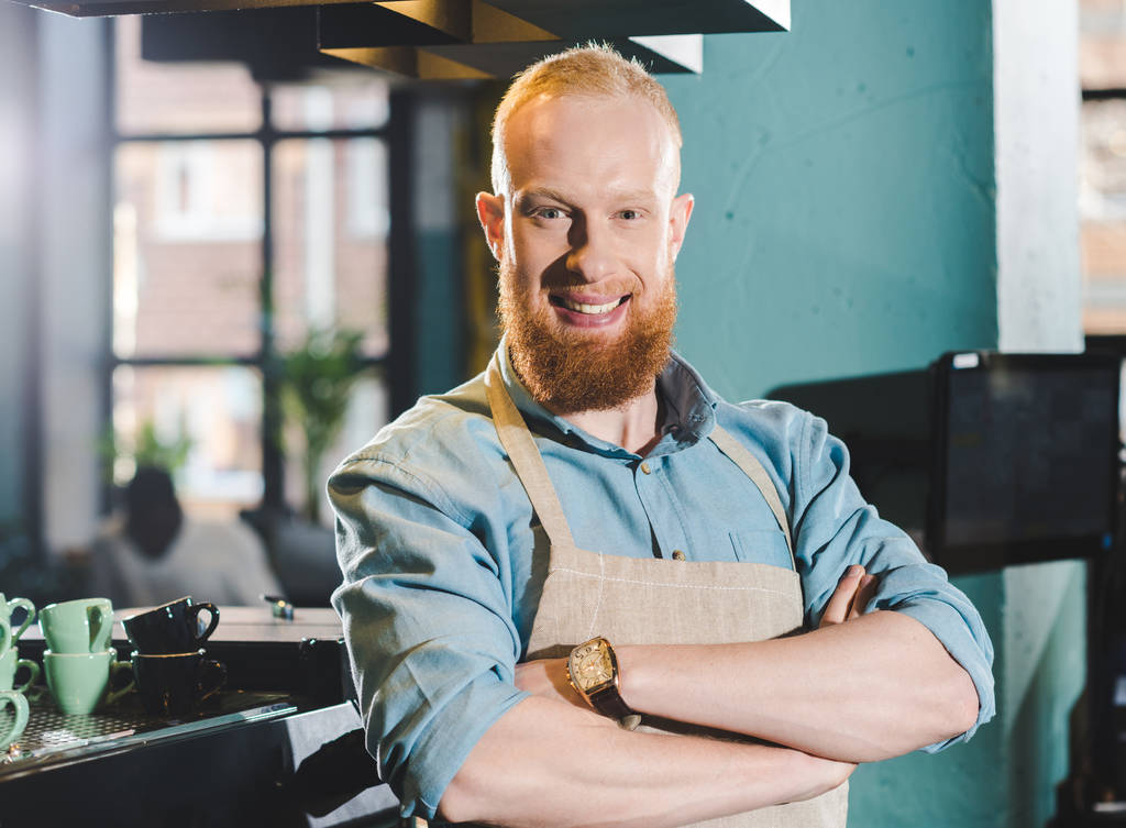 portrait of young male barista in apron standing with crossed arms  - Photo, Image