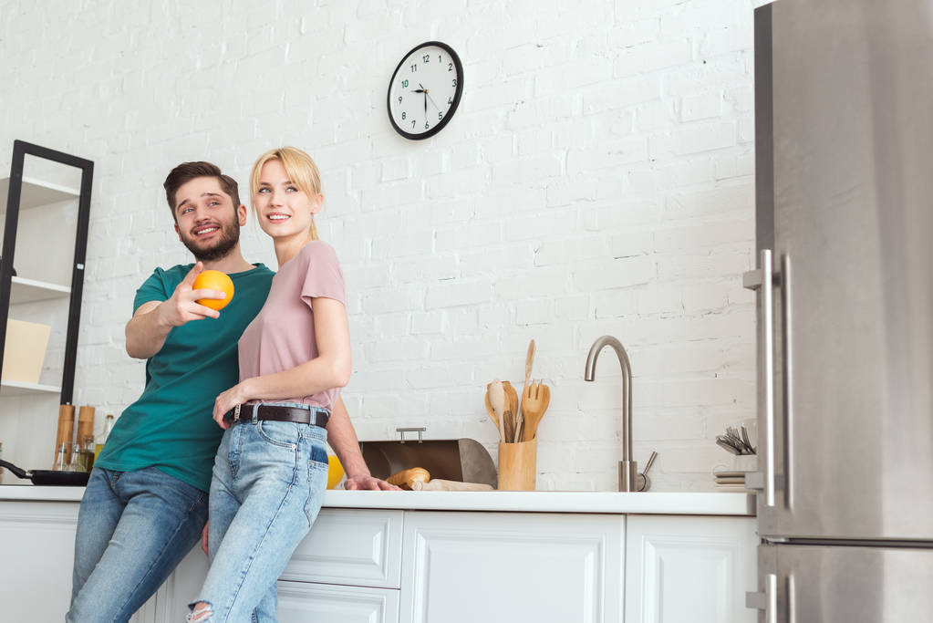 couple of vegans hugging and looking away at kitchen - Photo, Image