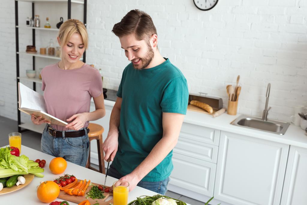 ζευγάρι των vegans μαγείρεμα με βιβλίο συνταγών στην κουζίνα - Φωτογραφία, εικόνα