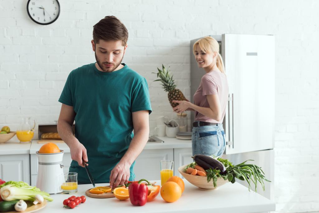 Freund schneidet Obst für veganes Essen in der Küche - Foto, Bild