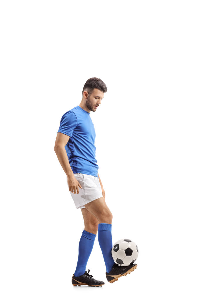 Full length profile shot of a soccer player juggling a football isolated on white background - Photo, Image