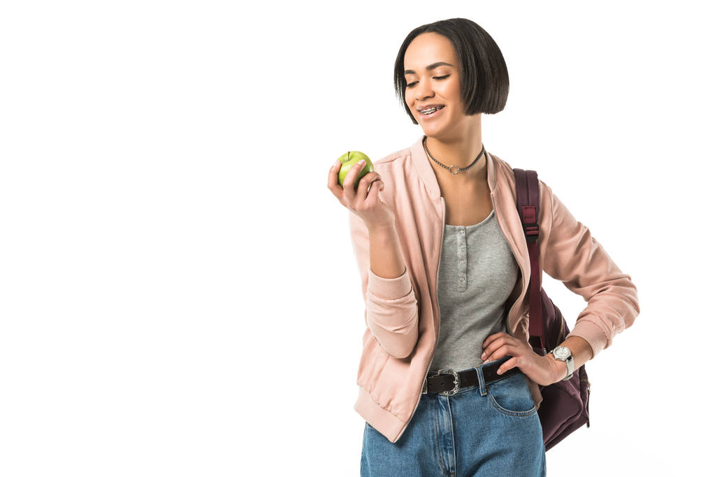 sorridente studentessa afroamericana con zaino in mano mela, isolata su bianco
 - Foto, immagini