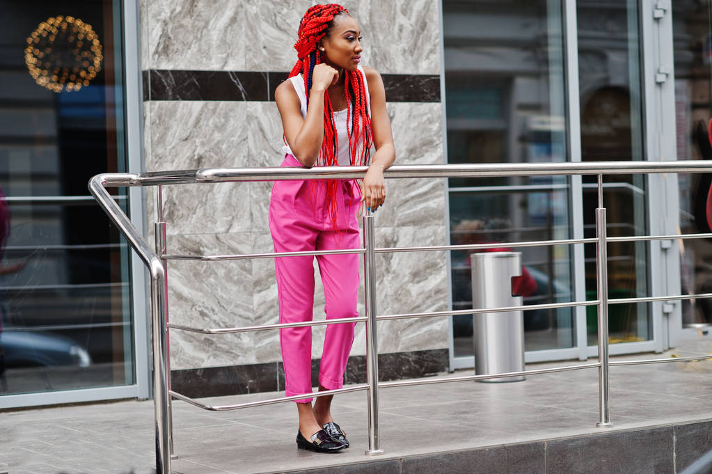 Muodikas afrikkalainen amerikkalainen tyttö vaaleanpunainen housut ja punainen rastat p
 - Valokuva, kuva