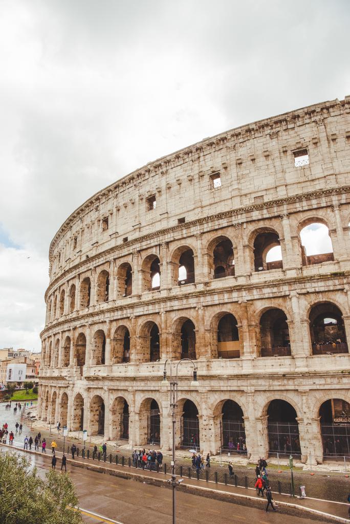 Rzym, Włochy - 10 marca 2018: ruiny Koloseum z turystów przechodzących pochmurny dzień - Zdjęcie, obraz