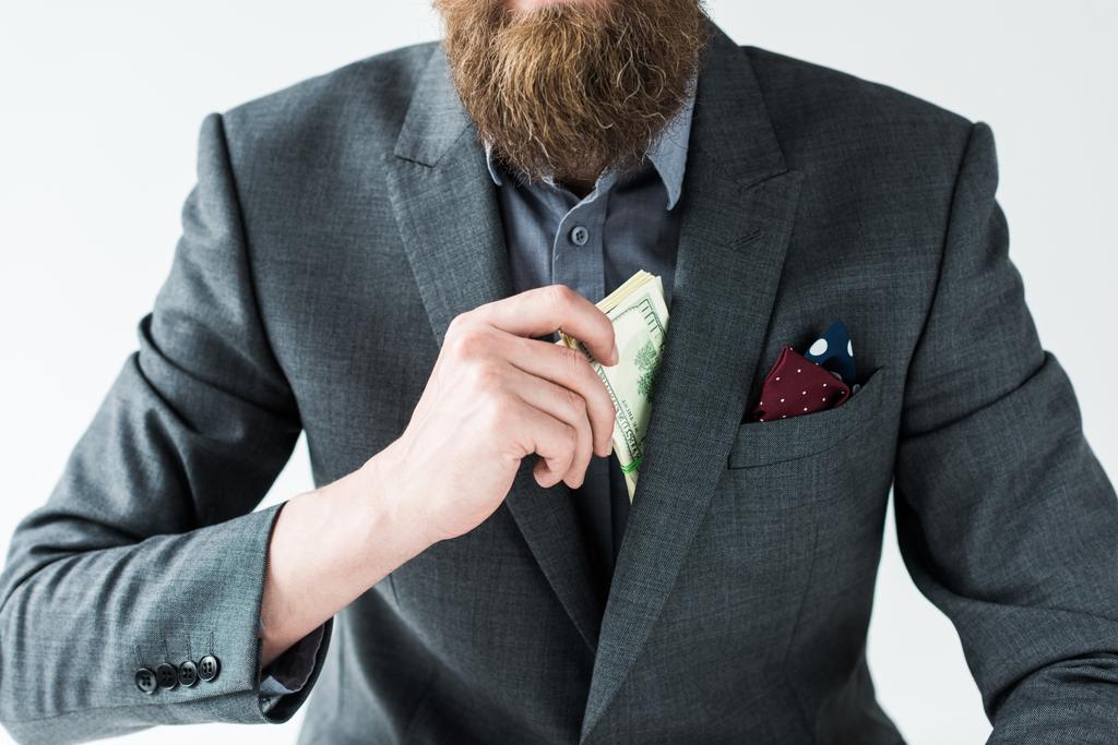 Vista recortada del hombre barbudo sacando dinero de su bolsillo aislado sobre fondo claro
 - Foto, imagen