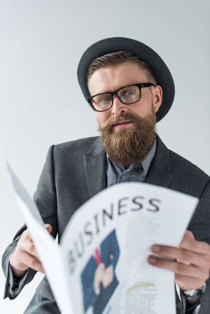 Empresário com bigode vintage e leitura de barba jornal de negócios isolado no fundo claro
 - Foto, Imagem