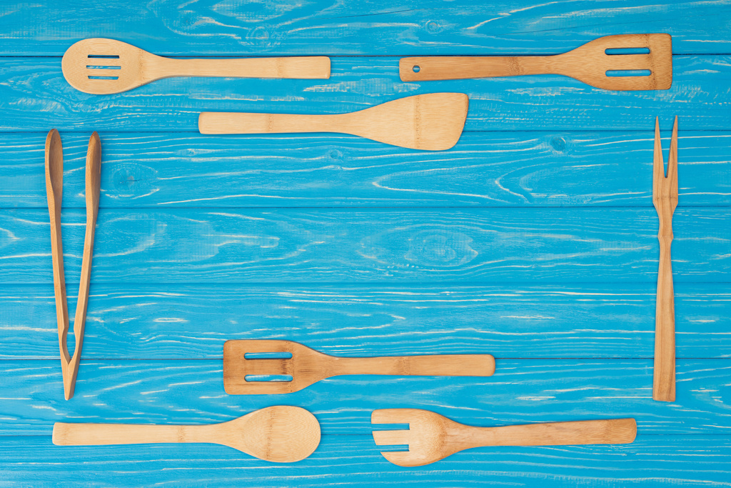 верхний вид набора кухонной утвари на голубой деревянный стол
 - Фото, изображение