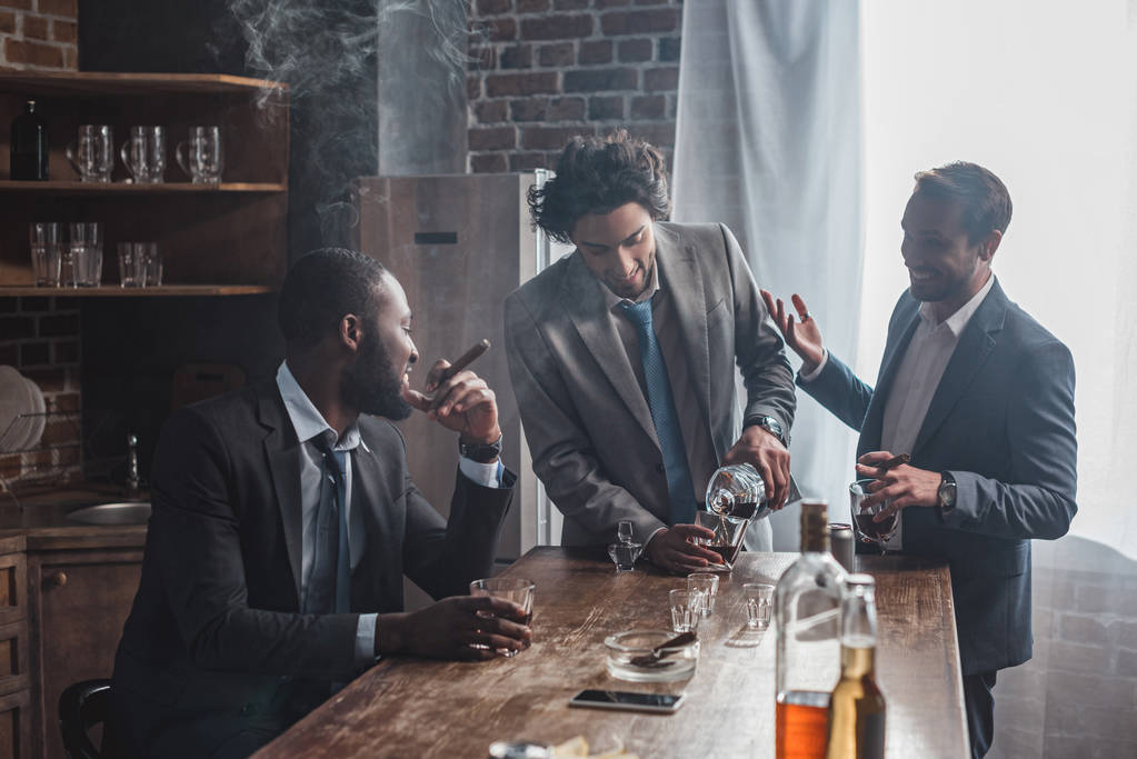 друзья-мужчины разговаривают во время употребления алкоголя и курения сигар
 - Фото, изображение