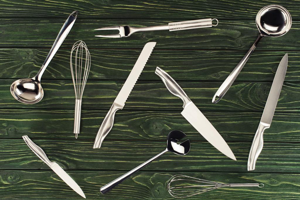 vista superior de utensilios de cocina metálicos sobre mesa de madera
  - Foto, imagen
