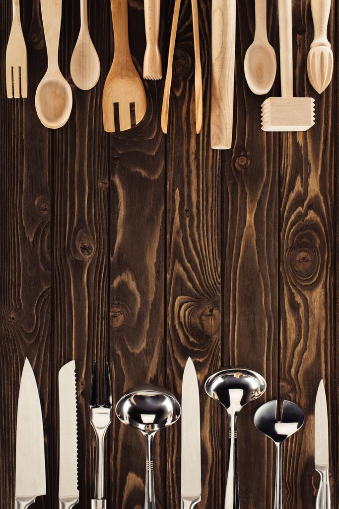 το Top view από μεταλλικά και ξύλινα σκεύη, που τοποθετούνται σε δύο γραμμές στον πίνακα  - Φωτογραφία, εικόνα