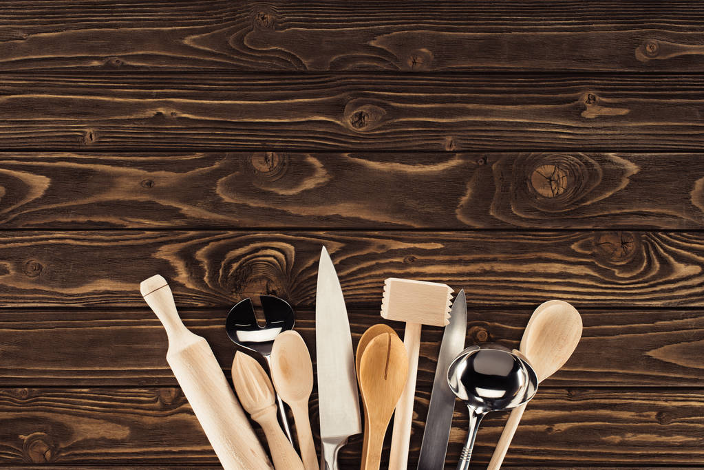 Blick von oben auf arrangierte Küchenutensilien auf Holztisch - Foto, Bild