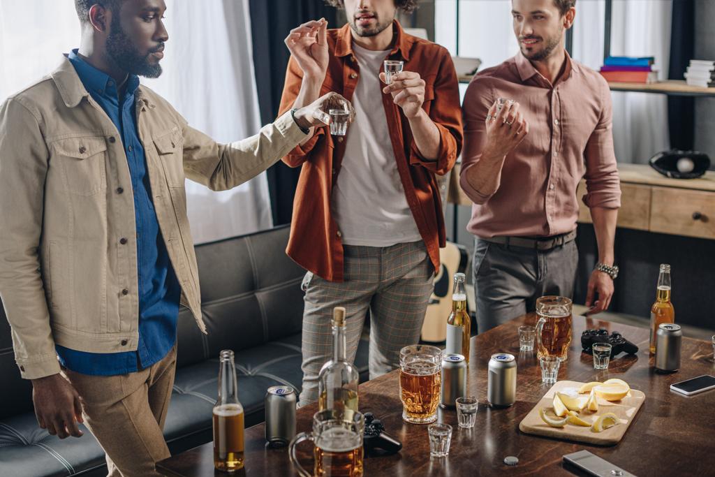 обрізаний знімок багатоетнічних друзів-чоловіків, які п'ють алкоголь разом
 - Фото, зображення