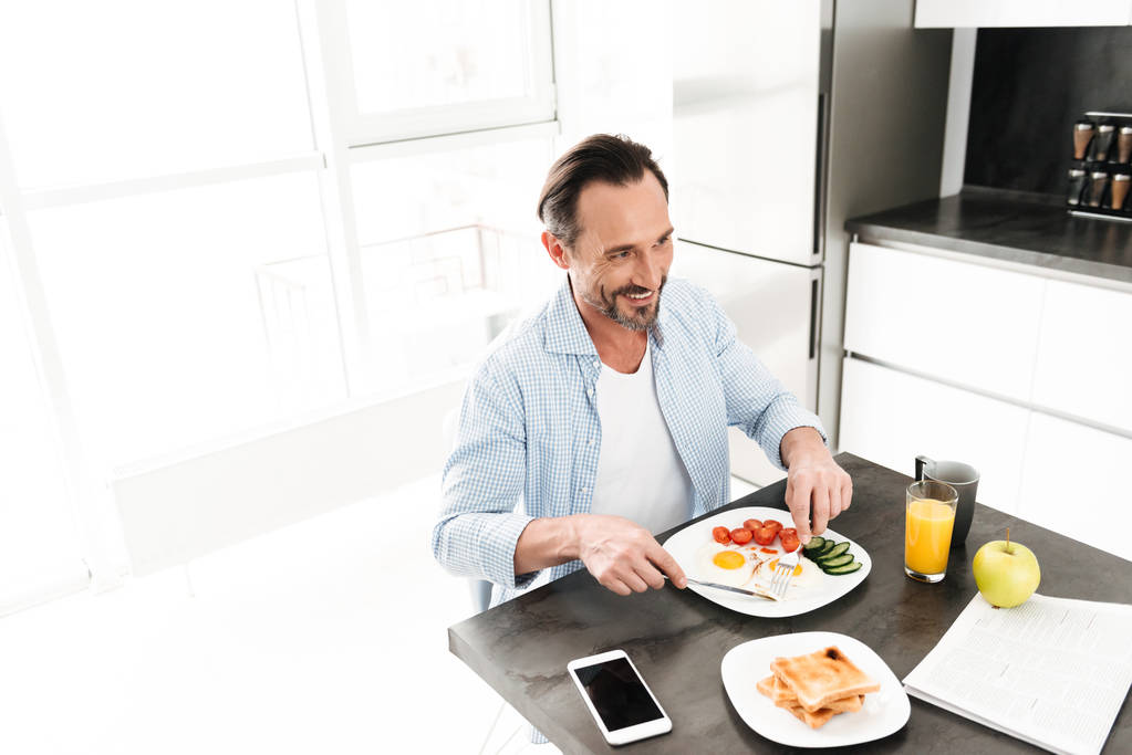 おいしい健康的な朝食を持って笑顔の成熟した男 - 写真・画像