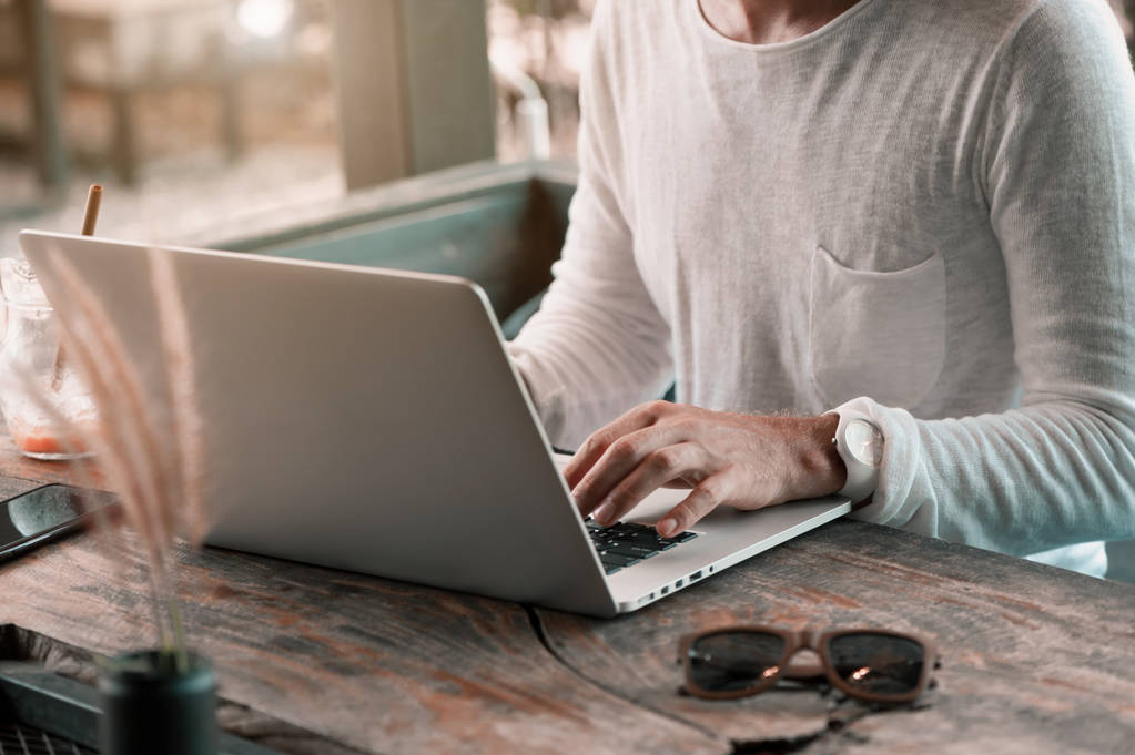 Молодой фрилансер, сидящий в кафе и работающий на ноутбуке
 - Фото, изображение