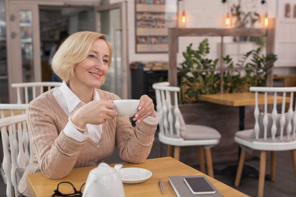 Iloinen nainen rentouttava kahvilassa
 - Valokuva, kuva