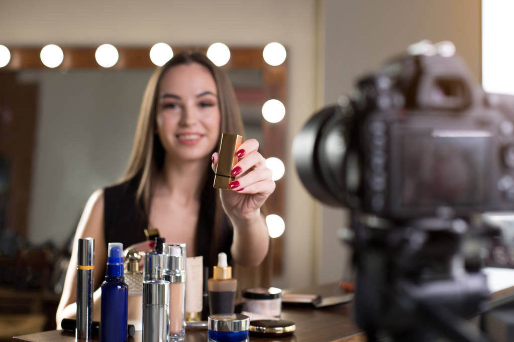 fröhliches Mädchen dreht Video über ihre Make-up-Produkte - Foto, Bild