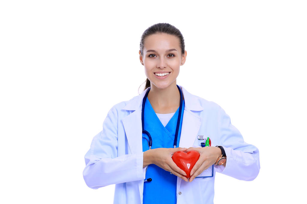 Positive female doctor standing with stethoscope and red heart symbol isolated. Woman doctor - Photo, Image