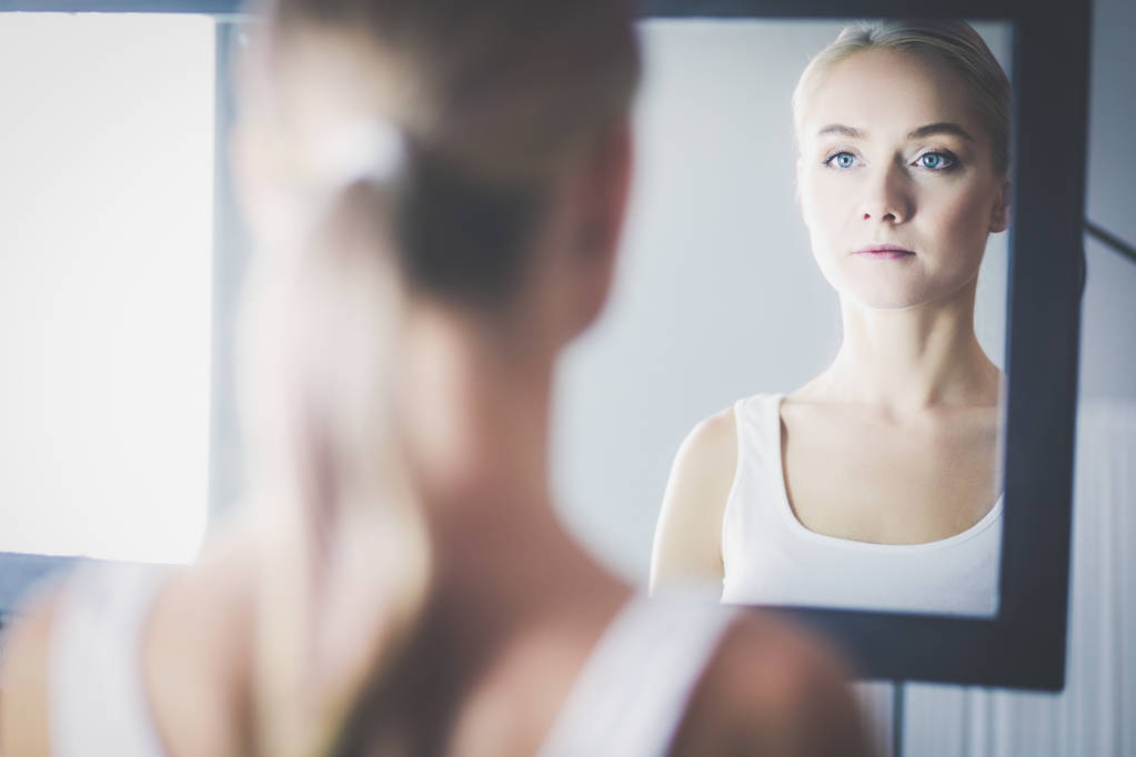rostro de joven hermosa mujer sana y la reflexión en el espejo
 - Foto, Imagen