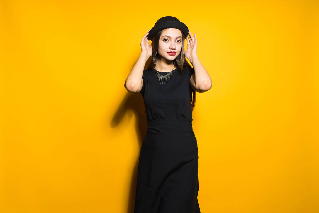 bela menina da moda em vestido elegante preto e chapéu posando no fundo laranja, modelo
 - Foto, Imagem