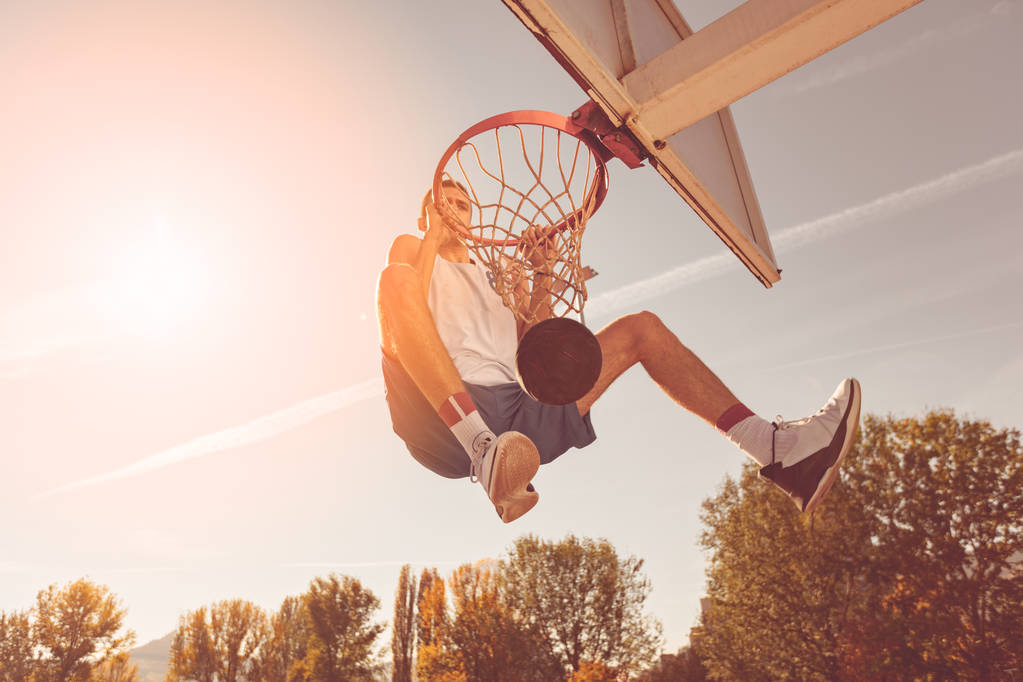Street-Basketball-Spieler führt Power-Slum-Dunk auf - Foto, Bild