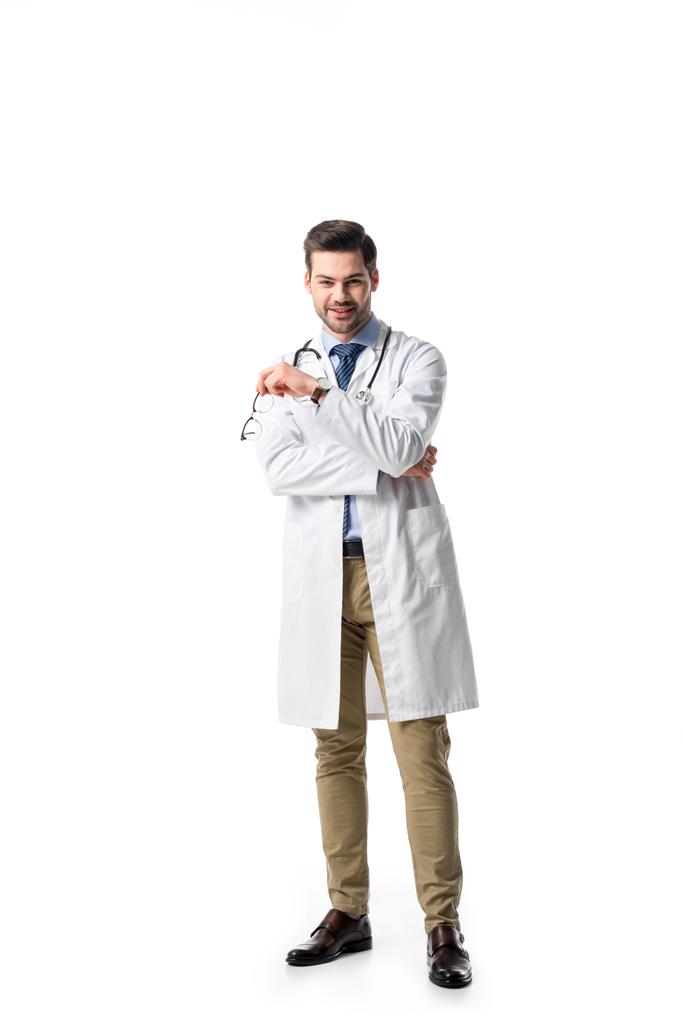 Médico sorridente vestindo casaco branco com estetoscópio isolado em branco
 - Foto, Imagem