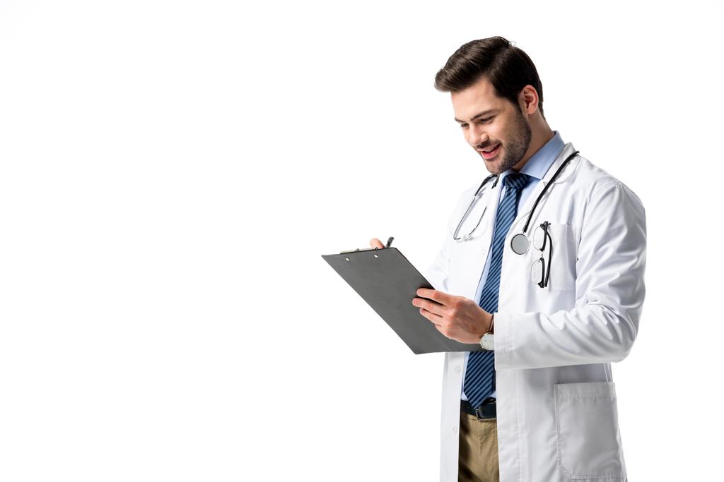 Dokter dragen witte vacht met de stethoscoop en schrijven diagnose in klembord geïsoleerd op wit - Foto, afbeelding