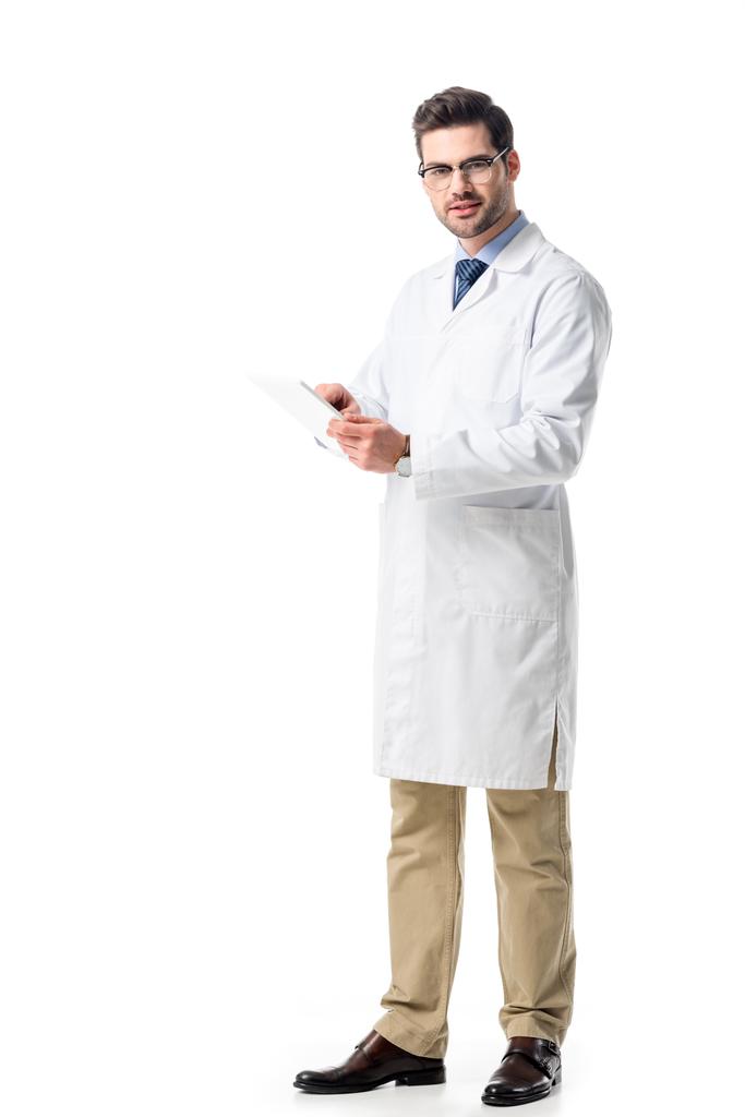 Γιατρός σε ποτήρια φορώντας άσπρο παλτό και χρησιμοποιώντας τα tablet που απομονώνονται σε λευκό - Φωτογραφία, εικόνα