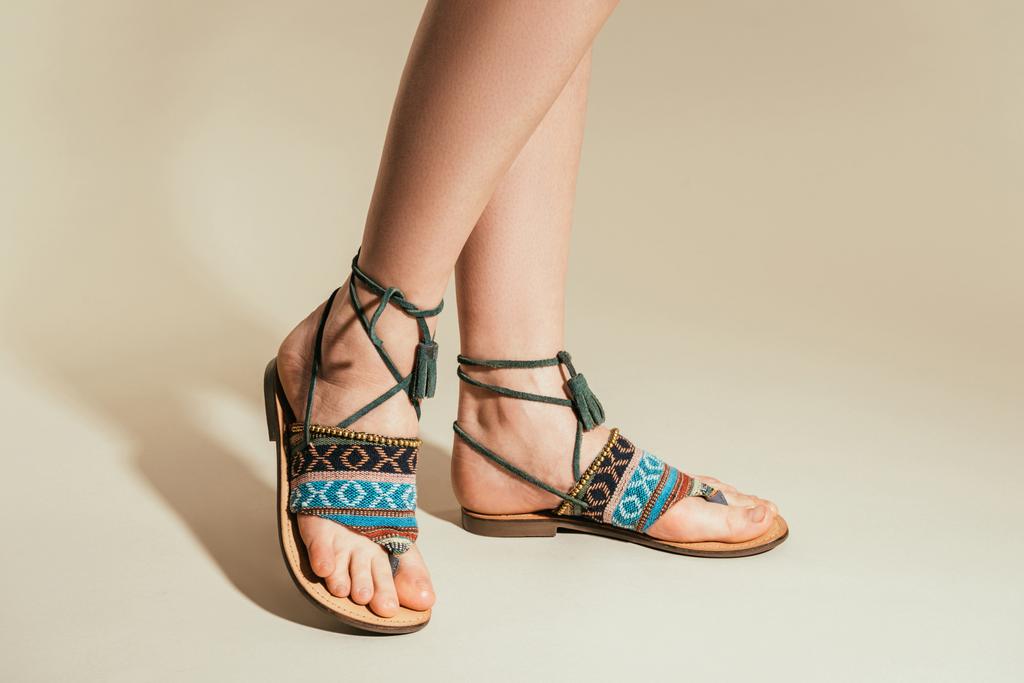 cropped shot of woman legs in stylish sandals on beige background - Photo, Image