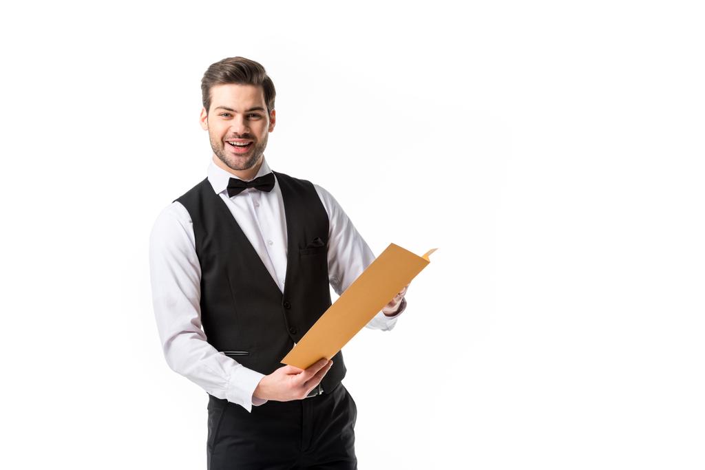 portrét usměvavý číšník v obleku vestu s menu izolované na bílém - Fotografie, Obrázek