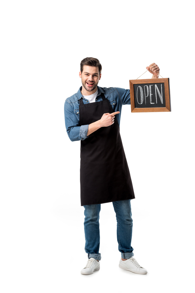 smiling waiter pointing at open blackboard in hand isolated on white - Photo, Image
