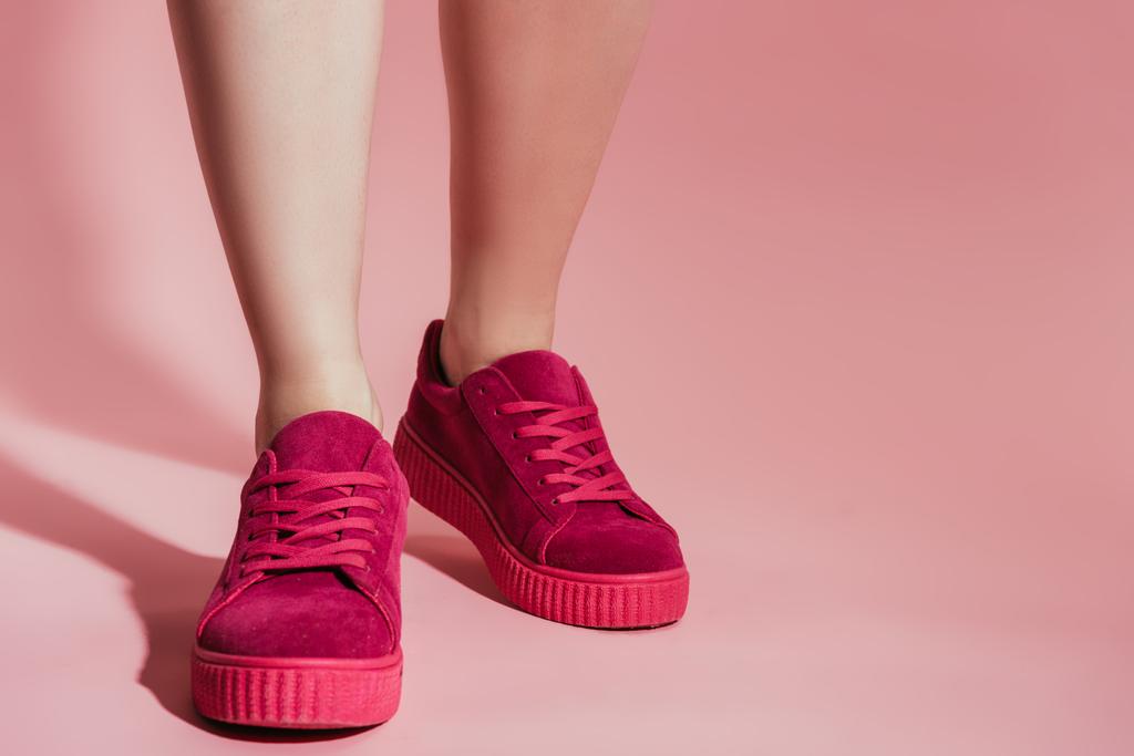 image recadrée de jambes de femme dans des baskets élégantes sur fond rose
 - Photo, image