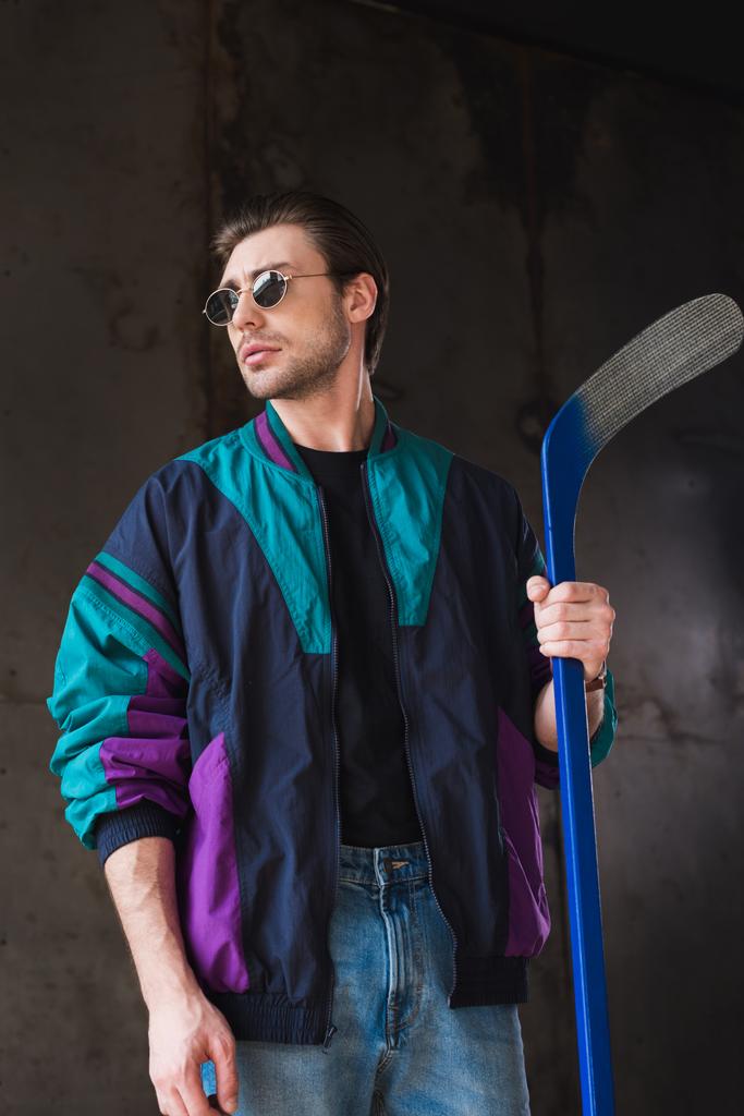 handsome young man in vintage windcheater with hockey stick - Photo, Image
