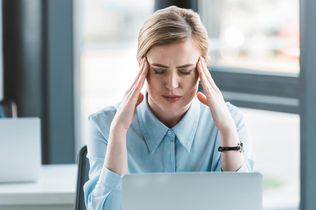 Geschäftsfrau leidet unter Kopfschmerzen bei der Arbeit mit Laptop - Foto, Bild